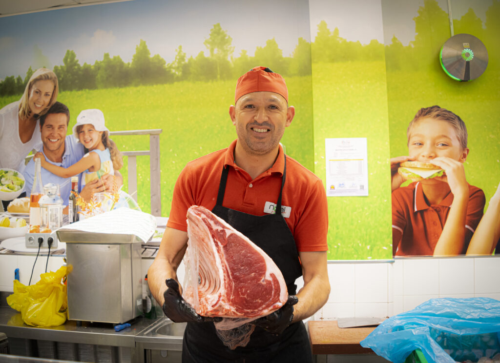 Noel supermercados. Carnicero sujetando trozo de carne