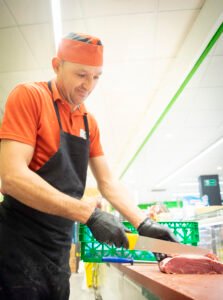 sobre Noel Supermercados. Carnicero cortando carne
